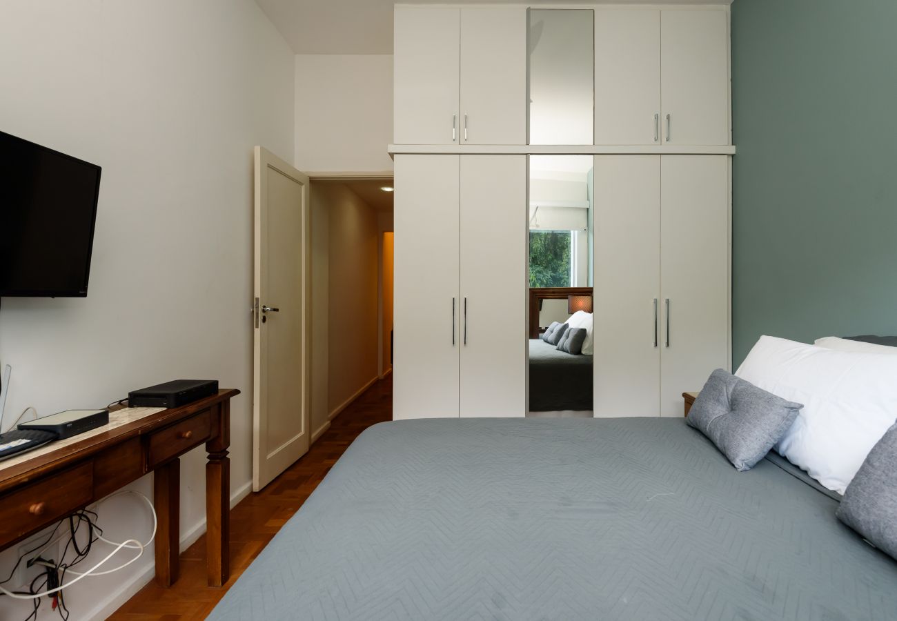 Bedroom with double bed, wardrobe and TV.