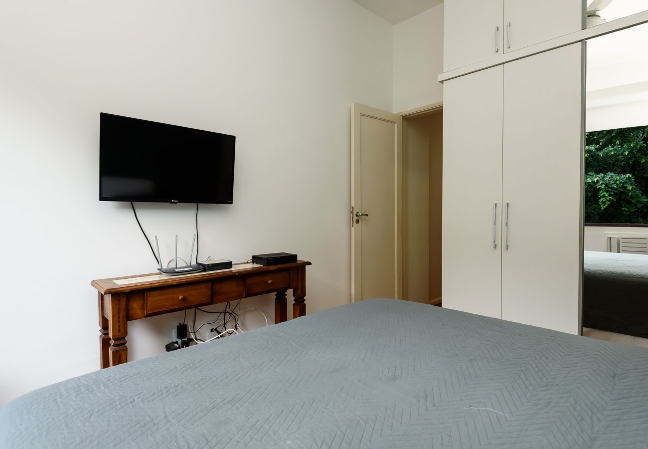 Bedroom with double bed, wardrobe and TV.